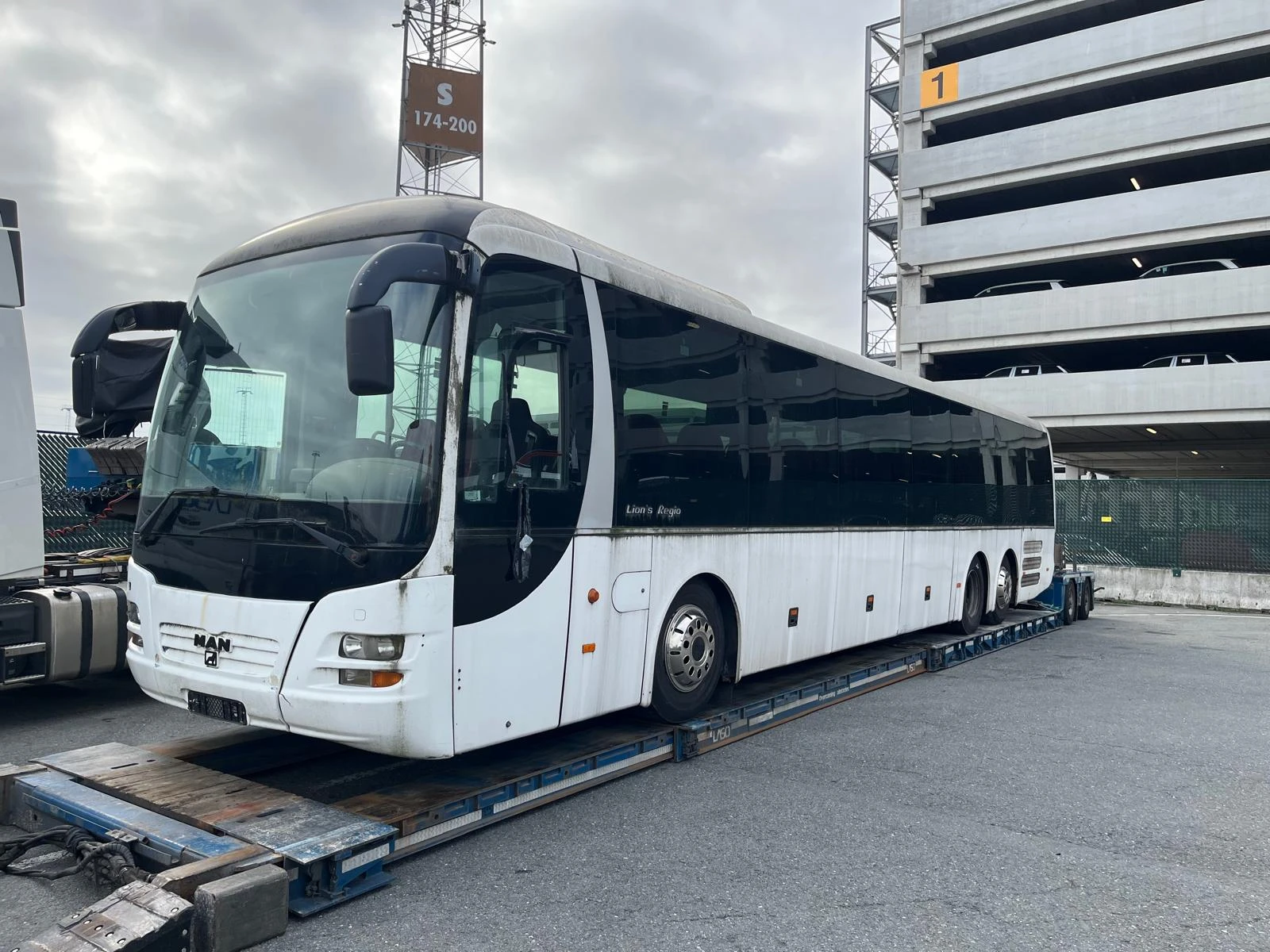 MAN Lion’s Regio touringcar op een dieplader in de haven van Antwerpen